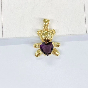 Macro view of panda bear pendant with heart-shaped purple zircon and gold texture