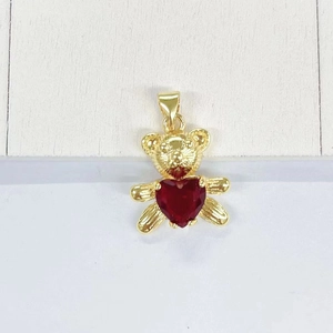 Detail view of golden panda pendant with red heart gemstone and fine textured finish