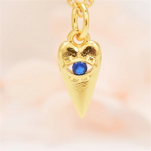 Macro-opname van vergulde evil eye hart hanger ketting met gezette blauwe zirkonia details