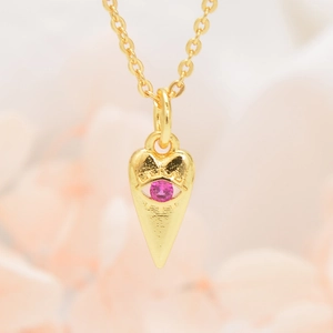 Gedetailleerd zicht op een goudkleurige boze oog hanger met roze zirkoon aan een ketting
