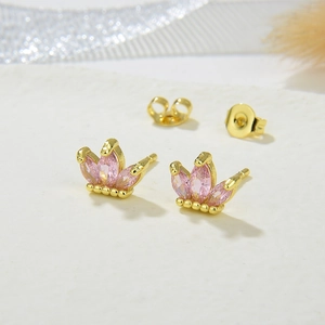 Detailed macro view of gold crown earrings with pink marquise zircons and butterfly backs