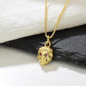 Nahaufnahme von vergoldetem Löwenkopf-Anhänger mit roten Zirkonia-Augen auf Kette