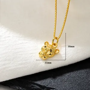 Makroaufnahme von 18k vergoldetem Tigerkopf-Anhänger mit schwarzen Zirkon-Augen auf Stein