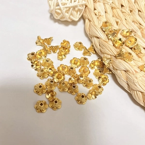 Detailed macro shot of hollow gold floral bead caps for DIY jewelry making and craft design