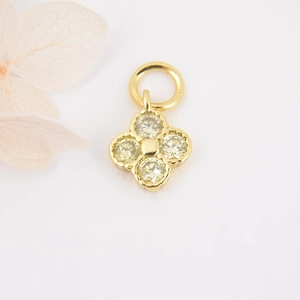 Detailed view of gold clover pendant with yellow zircons and pink flower petals