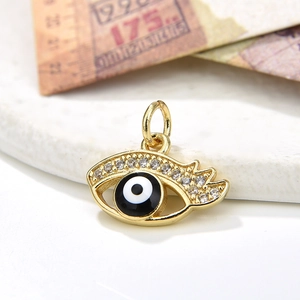 Gold evil eye pendant with cubic zirconia inlay and enamel eye on a stone base
