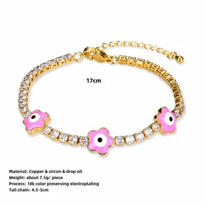 Dettaglio del bracciale tennis placcato oro 18K con fiori rosa e ciondoli occhio del diavolo