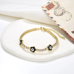 Dettaglio del bracciale tennis placcato oro 18K con ciondoli a fiore nero malocchio