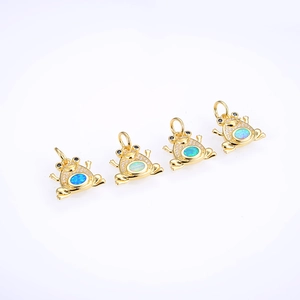 Macro detail of four frog pendants with blue opal center and micro-pave cubic zirconia