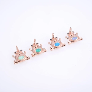 Close-up of four frog pendants with rose gold finish and colorful oval opal stones