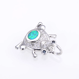 Silver frog pendant with teal opal and sparkling cubic zirconia stones on white background