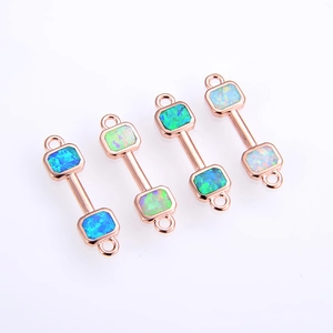 Macro view of dumbbell connectors in rose gold finish with vibrant colorful opal inlays