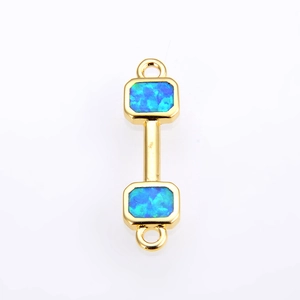 Macro view of gold-plated dumbbell jewelry connector with blue opal stones and dual ring loops