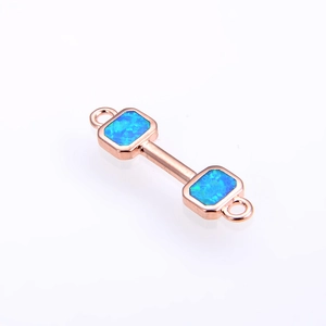 Detail of rose gold dumbbell jewelry connector with square blue opal stones