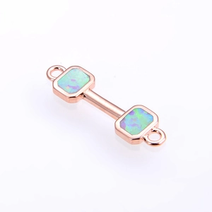 Macro detail of rose gold dumbbell connector with blue fire opal and double jewelry loops