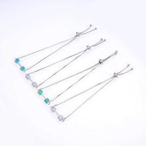 Detail view of adjustable box chain bracelets with square opal stones in four distinct colors