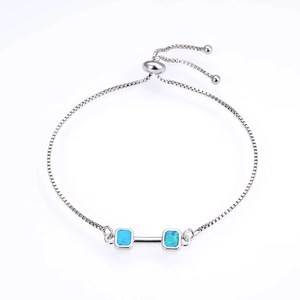 Detailed shot of an adjustable box chain bracelet with rectangle opal dumbbell accents