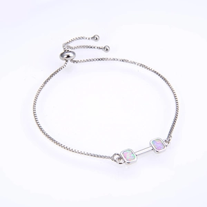 Detail of box chain bracelet with dumbbell pendant featuring pink opal inlay stones