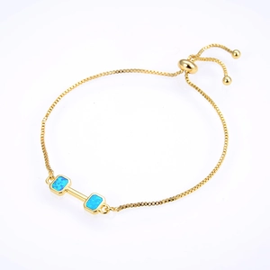 Detail view of golden bolo bracelet with blue opal dumbbells and adjustable box chain