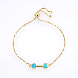 Detail view of a gold box chain bracelet with blue opal stones and adjustable slider