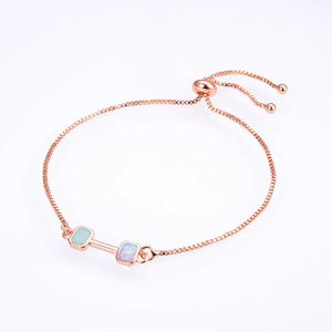 Macro detail of rose gold dumbbell slider bracelet featuring square opal insets