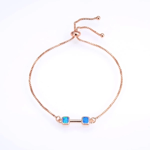 Rose gold adjustable box chain bracelet with blue opal dumbbell design on white background