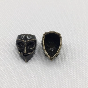 Macro shot of vintage Guy Fawkes mask alloy beads with antique finish for DIY bracelets