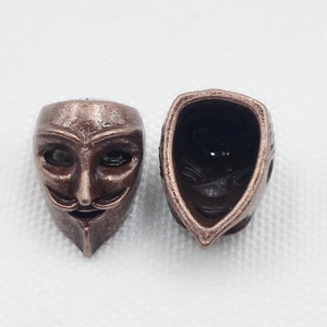 Macro view of vintage bronze alloy V for Vendetta mask charms for DIY jewelry making