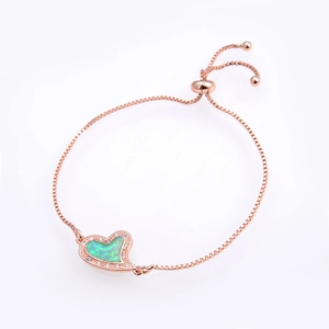 Detailed macro of rose gold heart bracelet with green opal inlay and box chain