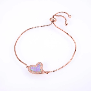 Macro detail of rose gold heart bracelet with opal inlay and adjustable slider clasp