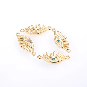 Close-up of gold-plated evil eye connectors with colorful opal inlay for DIY jewelry