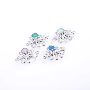 Detalle de cuatro dijes de pulpo con piedras de ópalo y baño de oro pulido