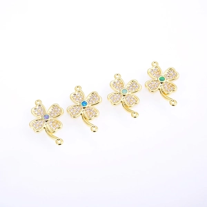 Detail of four-leaf clover jewelry pendants with gold plating and colorful opal stones