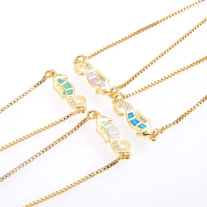 Detail von Seepferdchen Armbändern mit synthetischem Opal und goldener Box-Kettenstruktur