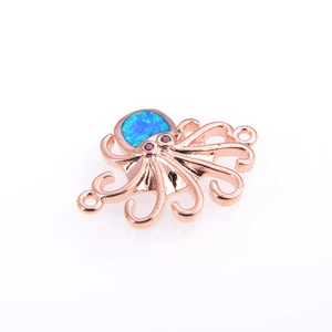 Detalle macro de dije de pulpo con ópalo azul y acabado en oro rosa de calidad