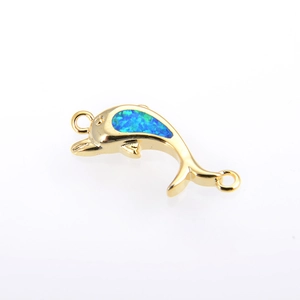 Détail d'un connecteur de bijoux dauphin en or avec incrustation d'opale bleue pour DIY