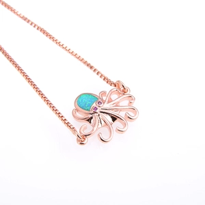 Detalle del colgante pulpo de oro rosa con ópalo verde y ojos de circón rosa