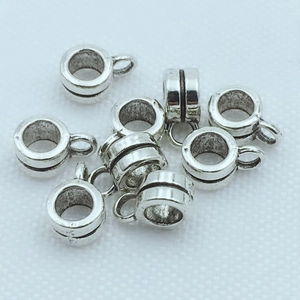Détail de perles cylindriques argentées avec boucles pour la création de bijoux DIY