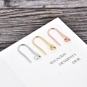 Detailed view of U-shaped earring hooks in gold, silver and rose gold finishes