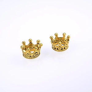 Paar vintage gouden legering kroon bedeltjes voor DIY sieraden op een witte achtergrond