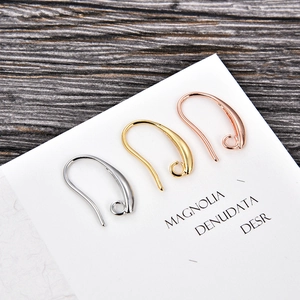 Macro detail of gold and silver U-shaped earring hooks on white display card