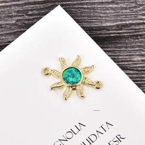 Detalle macro de dije de estrella dorada con opalo verde y cristales de circonita micro-pave