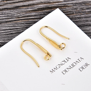 Detail of gold U-shaped earring hooks with textured leaf plate and loop for DIY jewelry