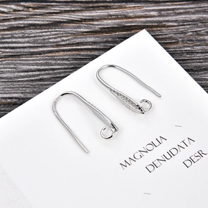 Macro shot of silver U-shaped earring hooks with detailed engraving for DIY jewelry