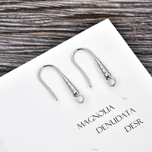 Detailed macro view of silver U-shaped earring hooks with screw thread and closed ring