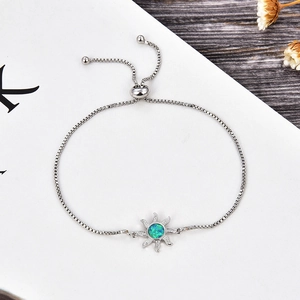 Detalle de pulsera de cadena ajustable con colgante de sol e incrustación de ópalo