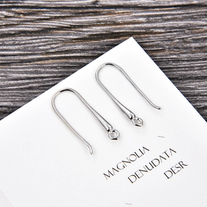 Detail of silver U-shaped earring hooks for DIY jewelry making on a white card