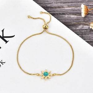 Detalle del dije de sol dorado con ópalo azul en pulsera de cadena de caja ajustable