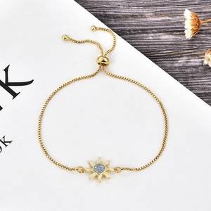 Detalle de pulsera de sol dorada con opalo purpura y cierre ajustable deslizante