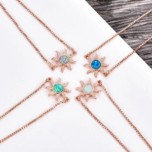 Detalle de colgantes de sol en oro rosa ajustables con piedras de opalo en cuatro colores